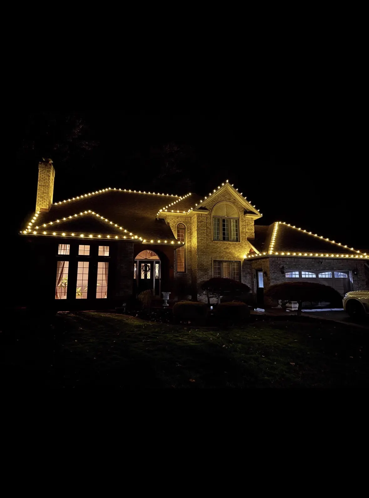 Warm white C9 lights along a residential roofline at night